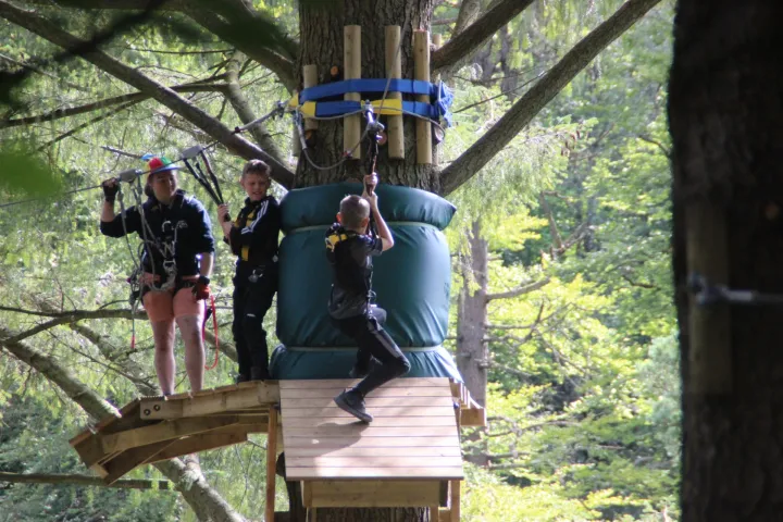 a group of people standing on top of a wooden bridge